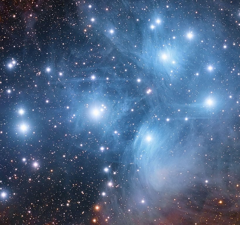 Photographs reveal the blue nebulosity that surrounds the Pleiades.
